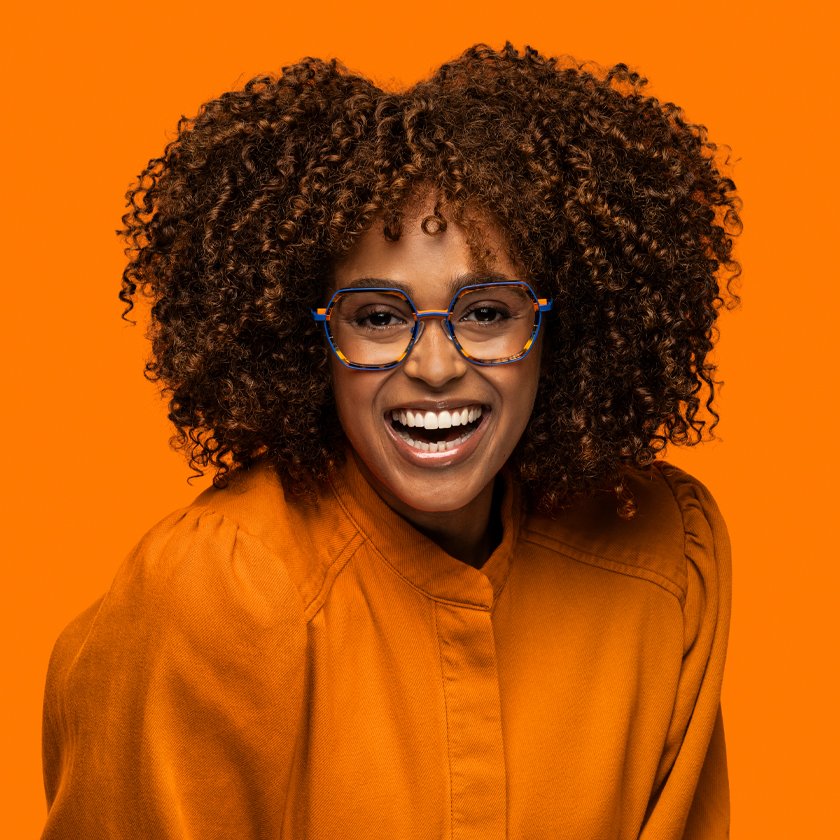 Mulher sorrindo com óculos Dutz em fundo laranja
